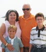 Author wearing orange shirt with his wife and two sons